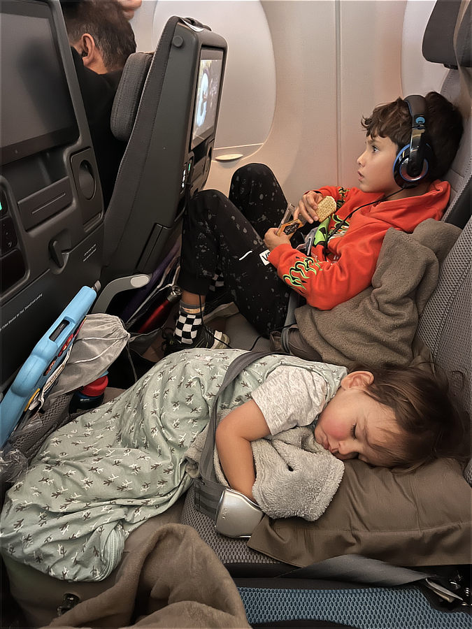 Child sleeping comfortably on an aeroplane during family travel